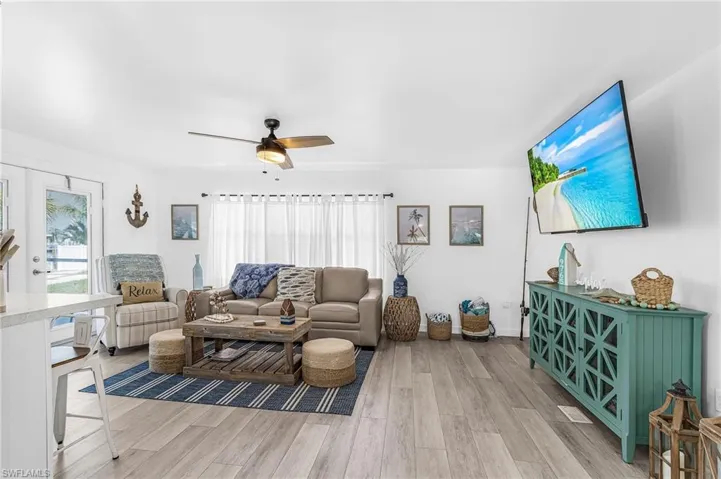 Open-concept living area featuring light wood-finish flooring and white walls