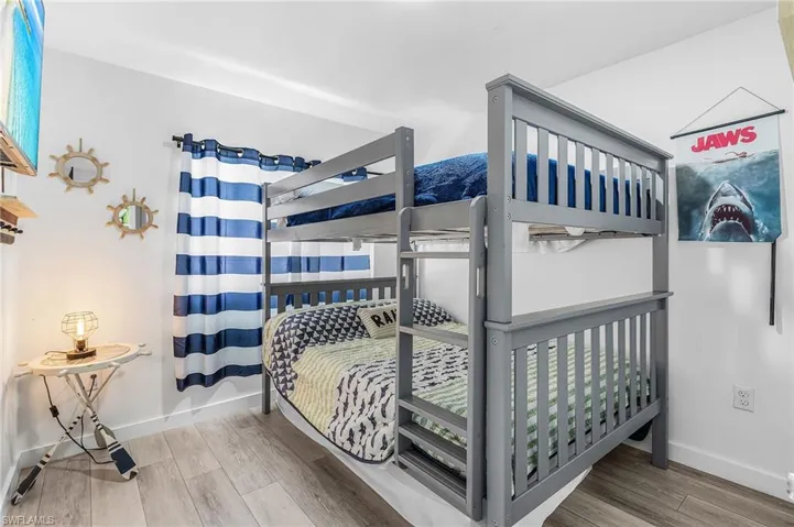 Gray bunk bed with slatted guardrails and an integrated ladder