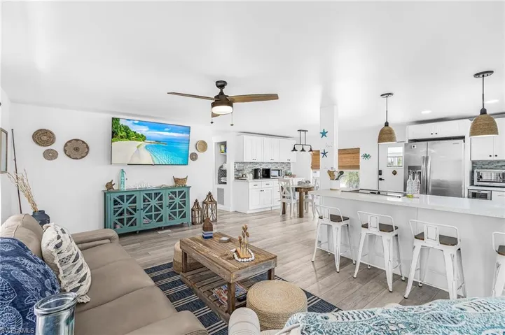 Open concept living area featuring wood-finish flooring, a ceiling fan, and recessed lighting