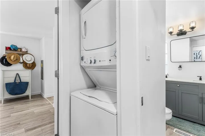 Dedicated laundry closet featuring a stacked washer and dryer unit