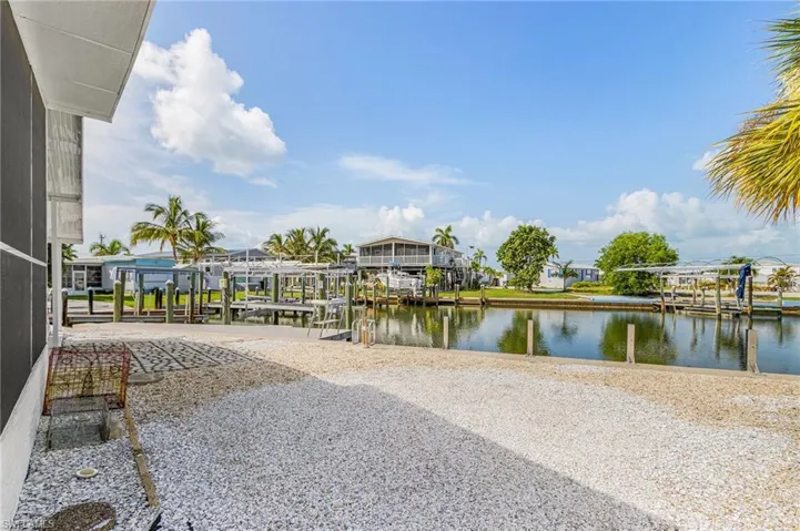 Waterfront property featuring a gravel-covered yard and a protected screened-in porch