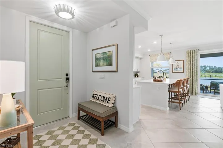 Entry foyer with light-toned paneled door, flush-mount ceiling fixture, and tile flooring