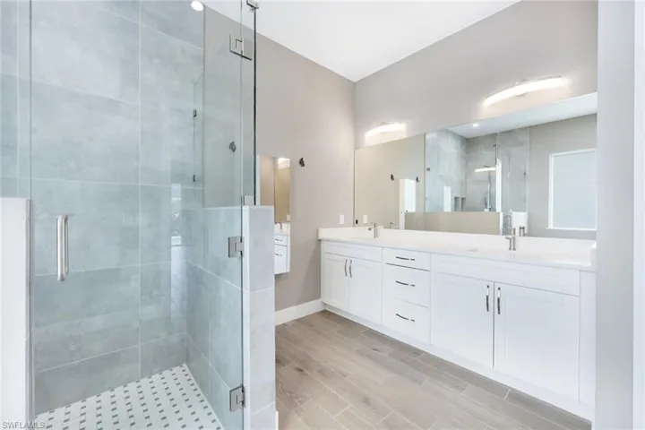 Bathroom featuring vanity and a shower with door