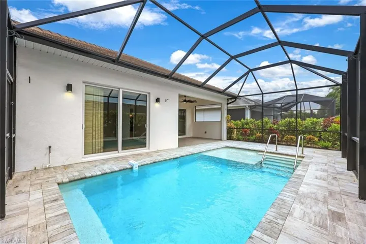 View of swimming pool with ceiling fan, a lanai, and a patio area