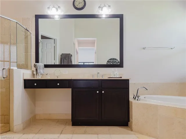 Full bathroom with a stall shower, vanity, and a garden tub