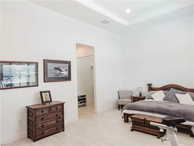 Bedroom featuring light wood-type flooring, a spacious closet, and recessed lighting