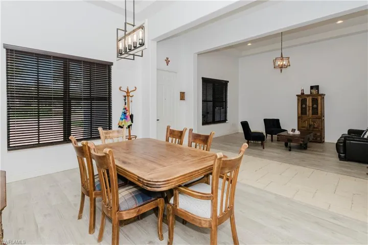 Dining room with light wood-type flooring, a chandelier, and recessed lighting