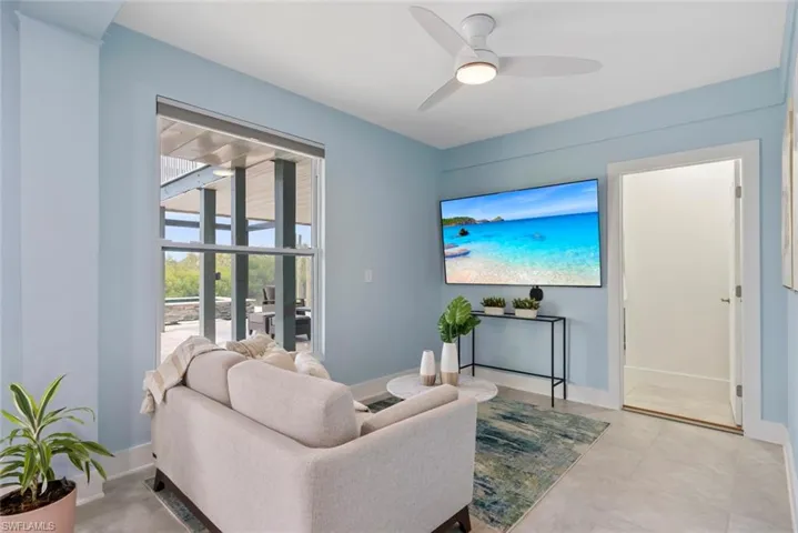 Living area featuring baseboards and a ceiling fan