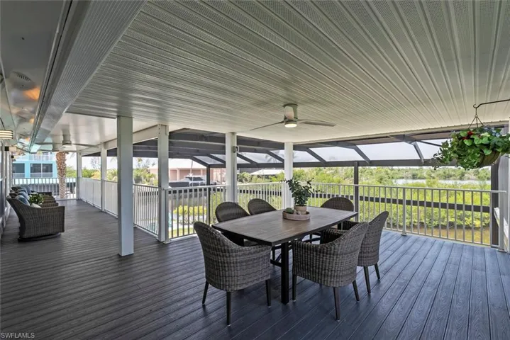 Wooden deck with outdoor dining area and a ceiling fan