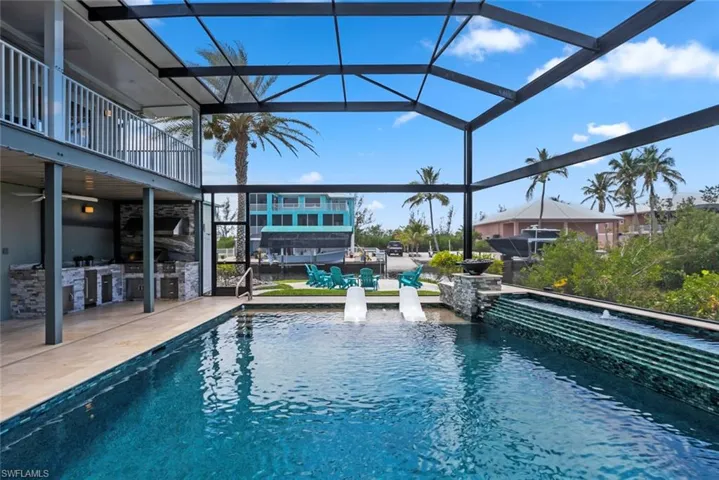 Pool featuring a patio, glass enclosure, ceiling fan, and area for grilling