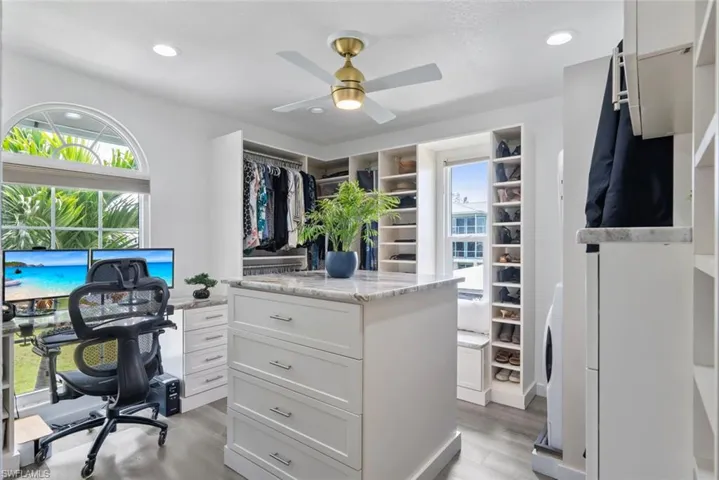 Spacious closet featuring a ceiling fan and light wood-style flooring