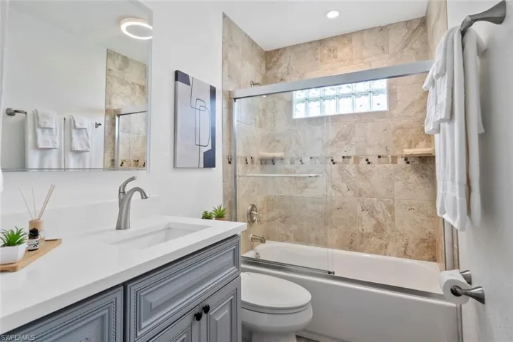 Full bathroom with toilet, combined bath / shower with glass door, and vanity