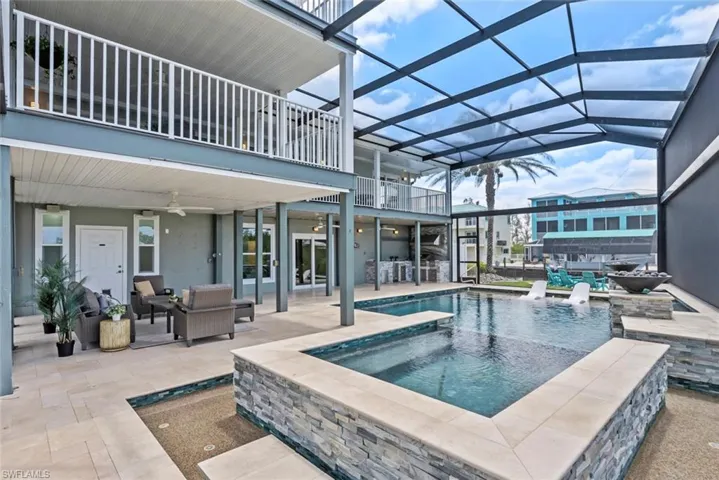View of swimming pool featuring ceiling fan, outdoor lounge area, a lanai, and a patio area