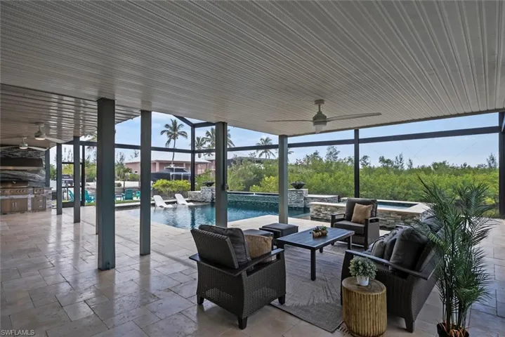 View of patio / terrace with an in ground hot tub, a ceiling fan, an outdoor pool, glass enclosure, and an outdoor hangout area