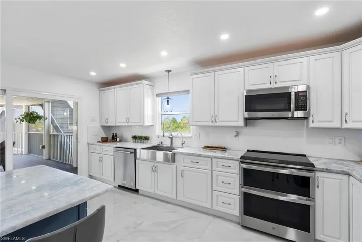 Kitchen with recessed lighting, white cabinets, and stainless steel appliances