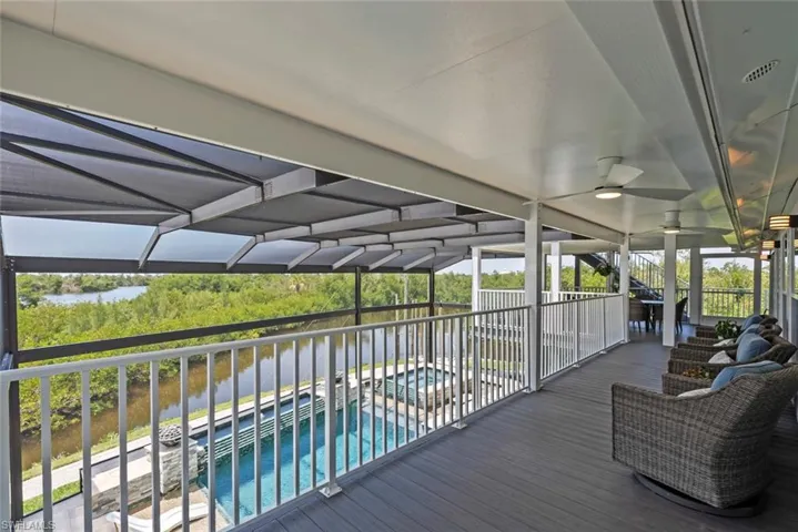 Wooden terrace featuring a ceiling fan and an outdoor pool