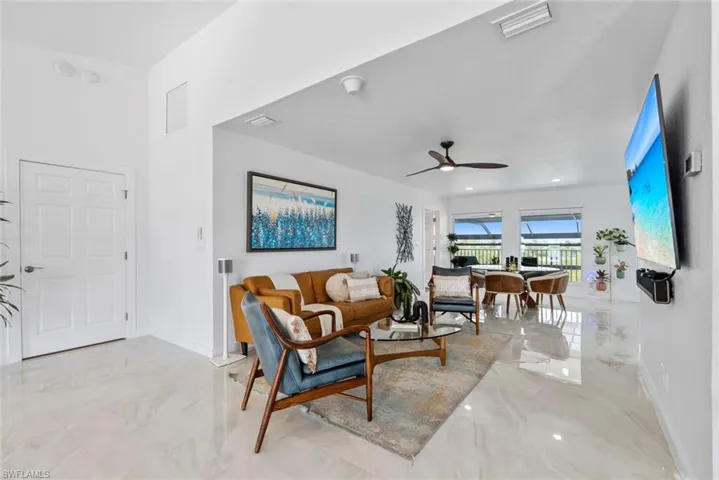 Living area featuring baseboards, marble finish floor, ceiling fan, and visible vents