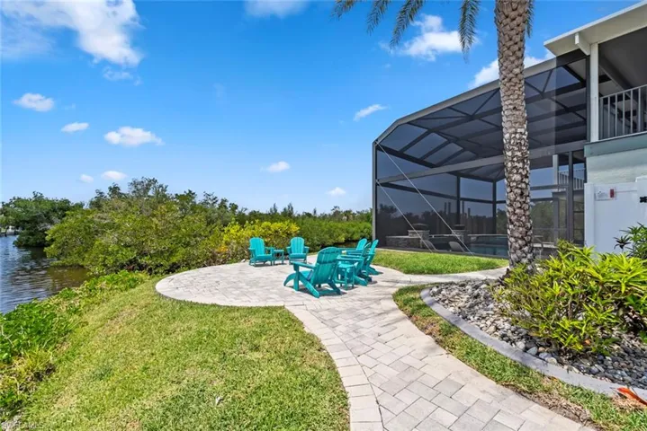View of yard featuring a patio, a water view, and glass enclosure