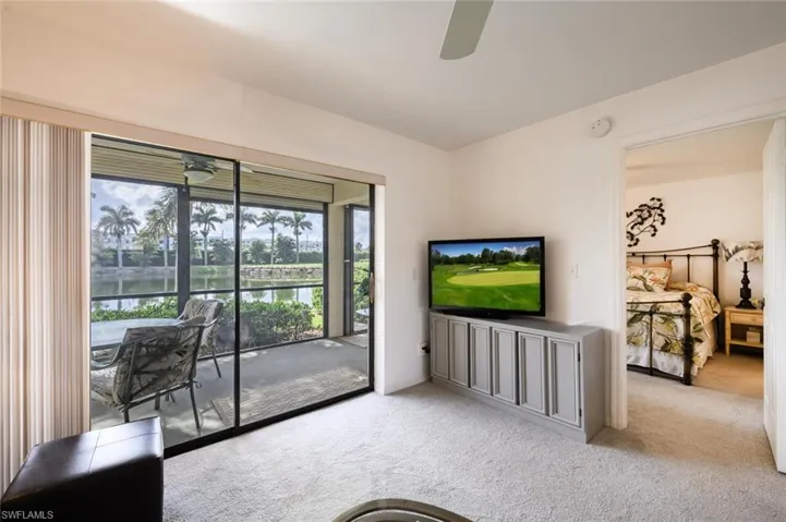 Living room with ceiling fan and light carpet