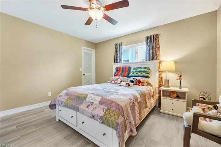 Bedroom with baseboards, ceiling fan, and light wood-style flooring