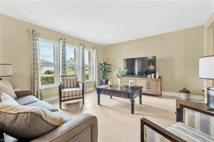 Living area with light tile patterned flooring and baseboards