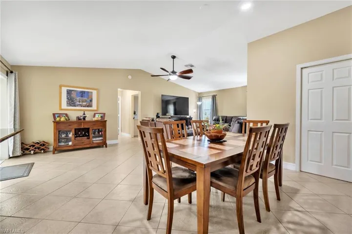 Dining area with lofted ceiling, ceiling fan, visible vents, and light tile patterned floors