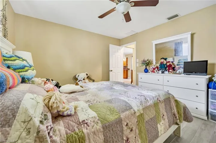 Bedroom featuring ceiling fan, visible vents, and wood finished floors