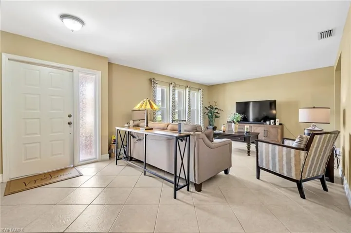 Living room with light tile patterned flooring and visible vents