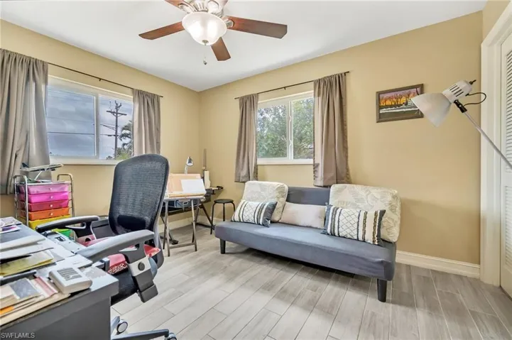 Office area with baseboards, ceiling fan, and light wood finished floors