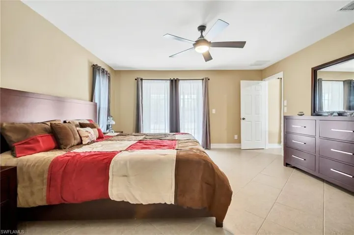 Bedroom featuring light tile patterned flooring, baseboards, visible vents, and a ceiling fan