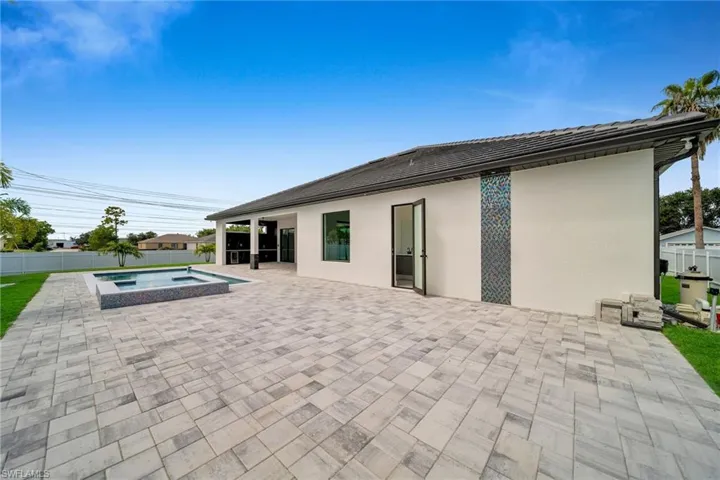 Rear view of property with a patio and a swimming pool with hot tub