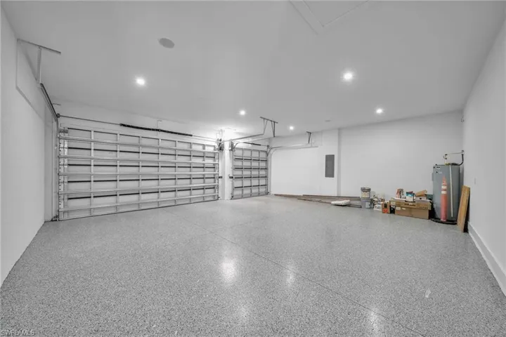 Garage featuring electric panel and water heater