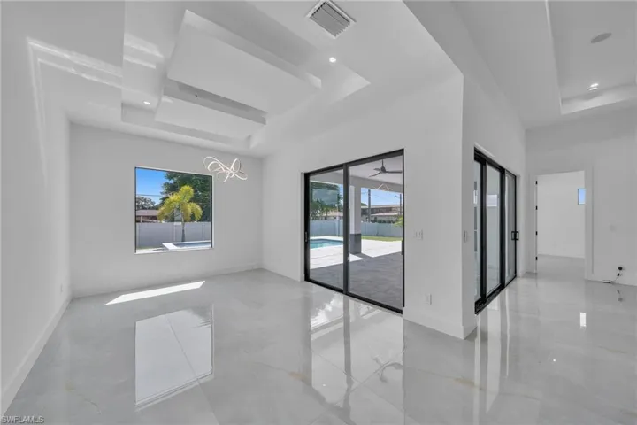 Empty room featuring a tray ceiling and a notable chandelier