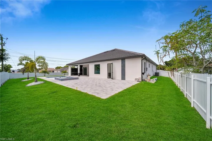 Back of house with a fenced in pool, a lawn, and a patio