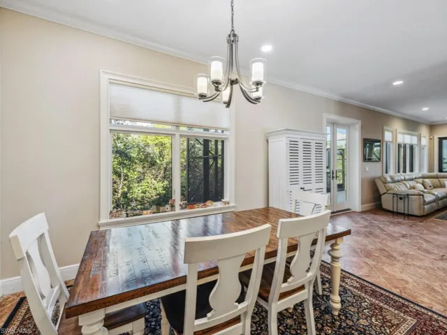 Dining area with plenty of natural light, an inviting chandelier, and ornamental molding
