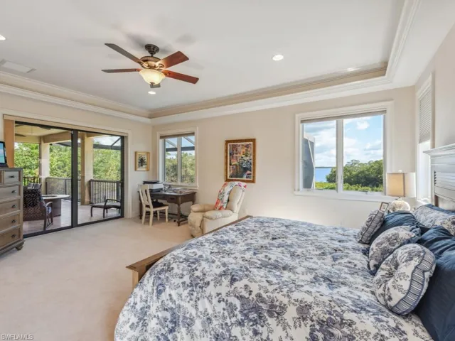 Carpeted bedroom with ceiling fan, access to exterior, and crown molding