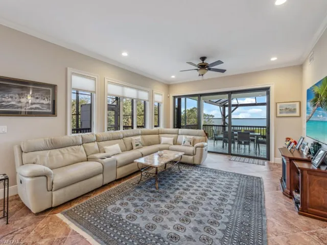 Living room featuring ceiling fan and ornamental molding