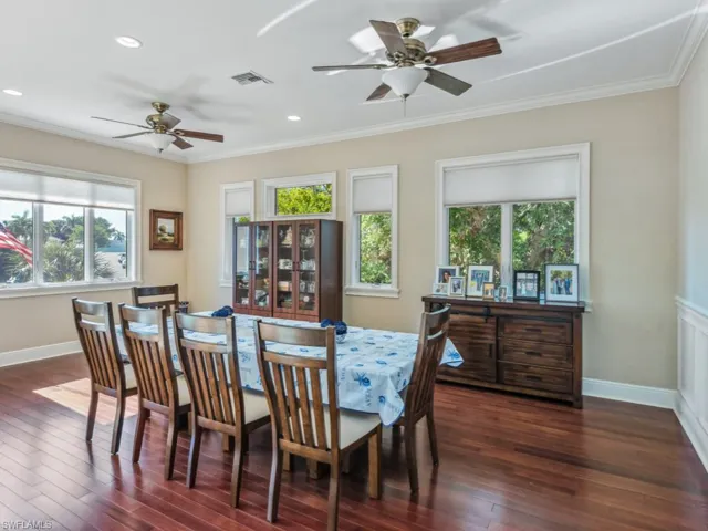 Dining space with ceiling fan, dark hardwood / wood-style floors, and ornamental molding