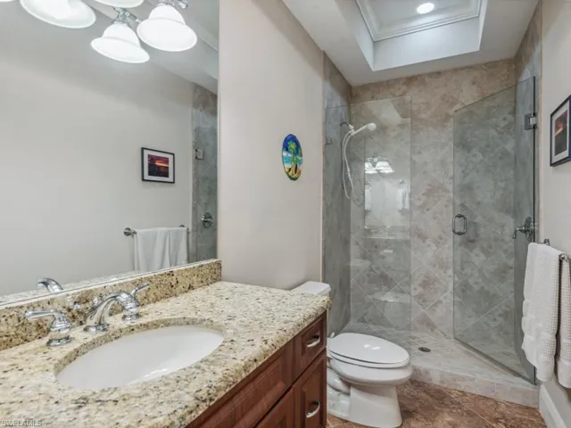 Bathroom featuring vanity, toilet, walk in shower, and crown molding