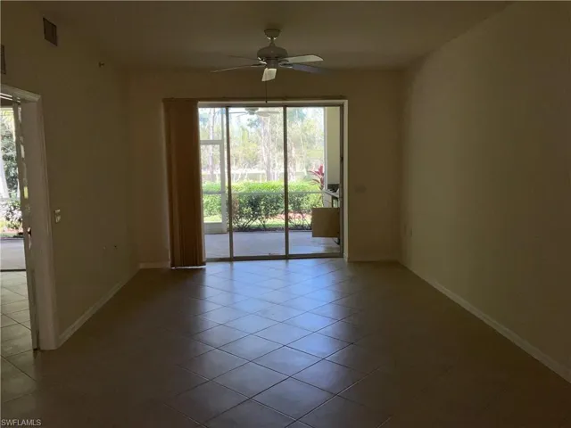 Empty room featuring tile patterned floors, baseboards, a ceiling fan, and visible vents