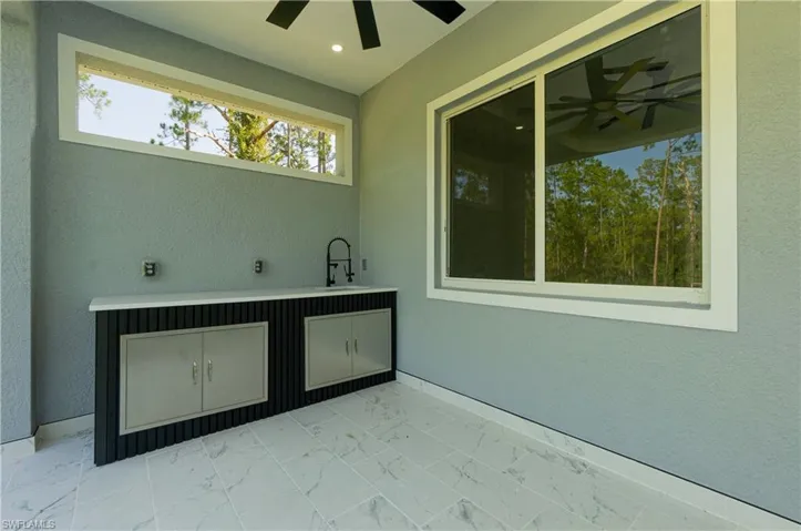 View of patio with a ceiling fan and a sink