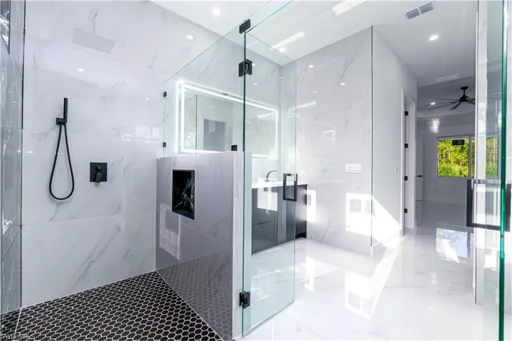 Bathroom featuring a marble finish shower, ceiling fan, marble tiled flooring, and recessed lighting