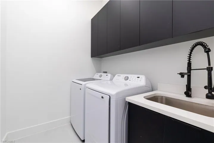 Washroom featuring cabinet space and washing machine and dryer