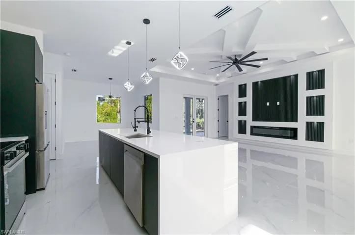 Kitchen with modern cabinets, light marble finish flooring, coffered ceiling, plenty of natural light, and recessed lighting