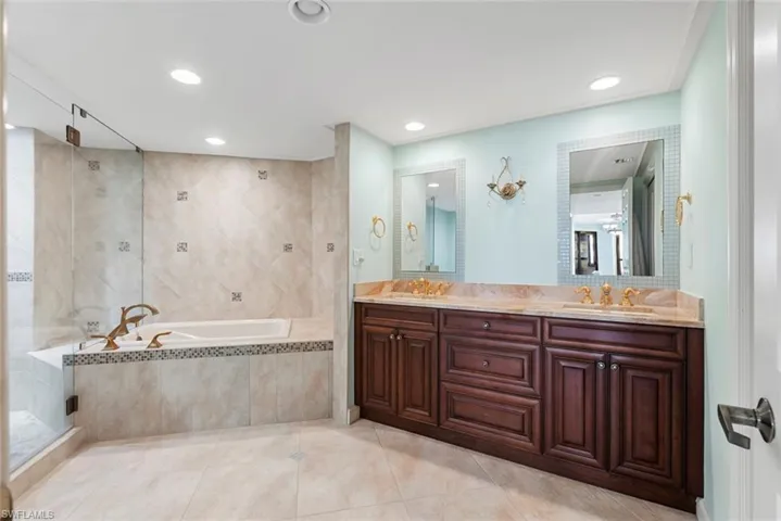 Bathroom with tile patterned flooring, vanity, and independent shower and bath