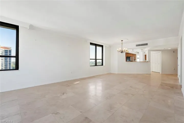 Unfurnished room with a notable chandelier