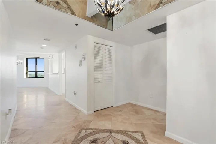 Hallway featuring a notable chandelier