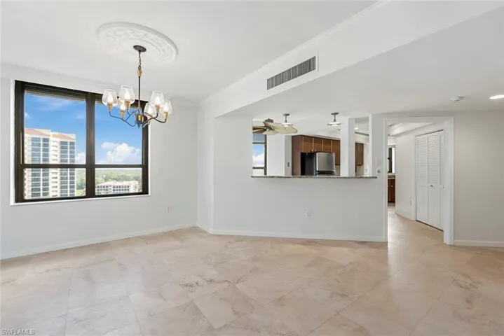 Empty room featuring ornamental molding and a chandelier