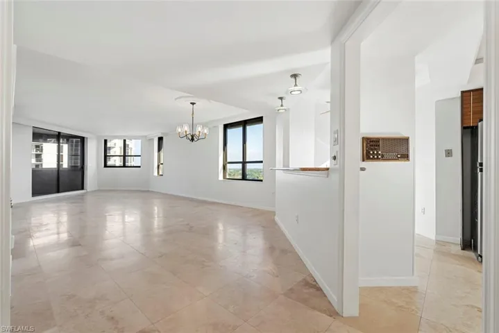 Empty room featuring a notable chandelier and light tile patterned floors