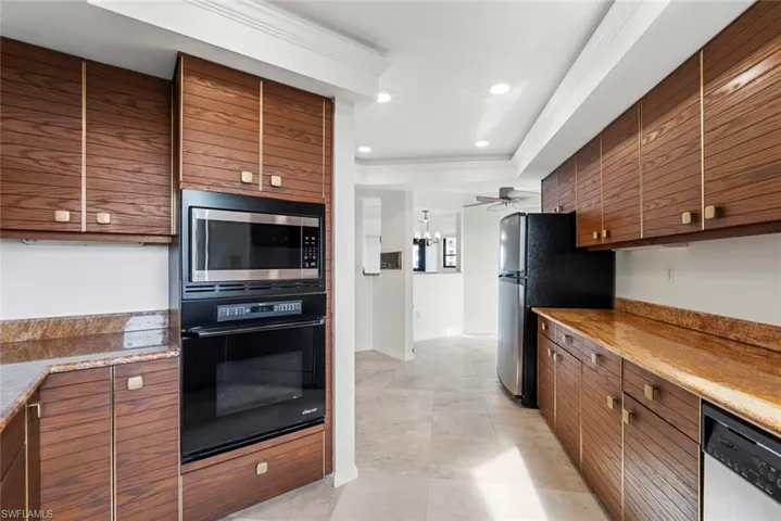 Kitchen featuring ceiling fan with notable chandelier, crown molding, and appliances with stainless steel finishes
